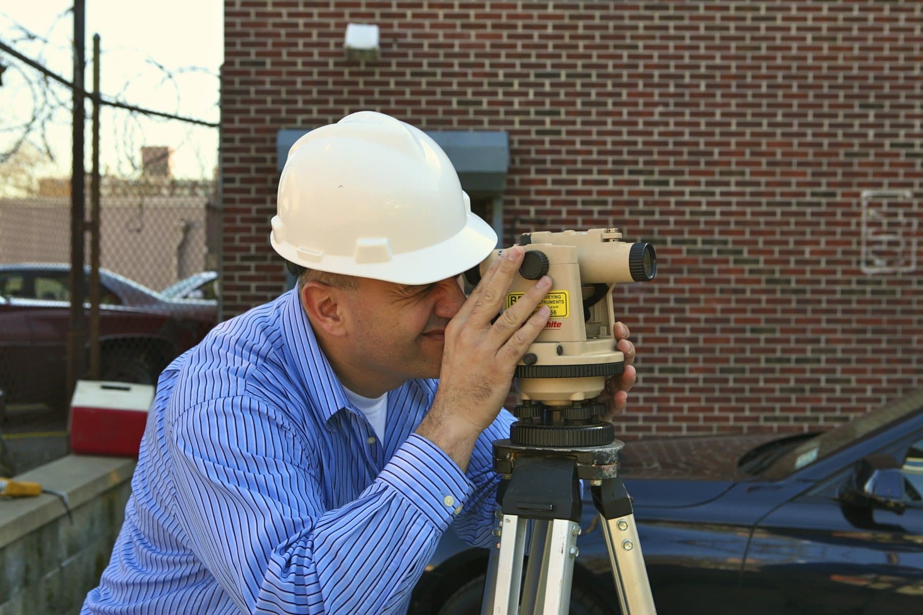HTE engineer surveying a site with a level