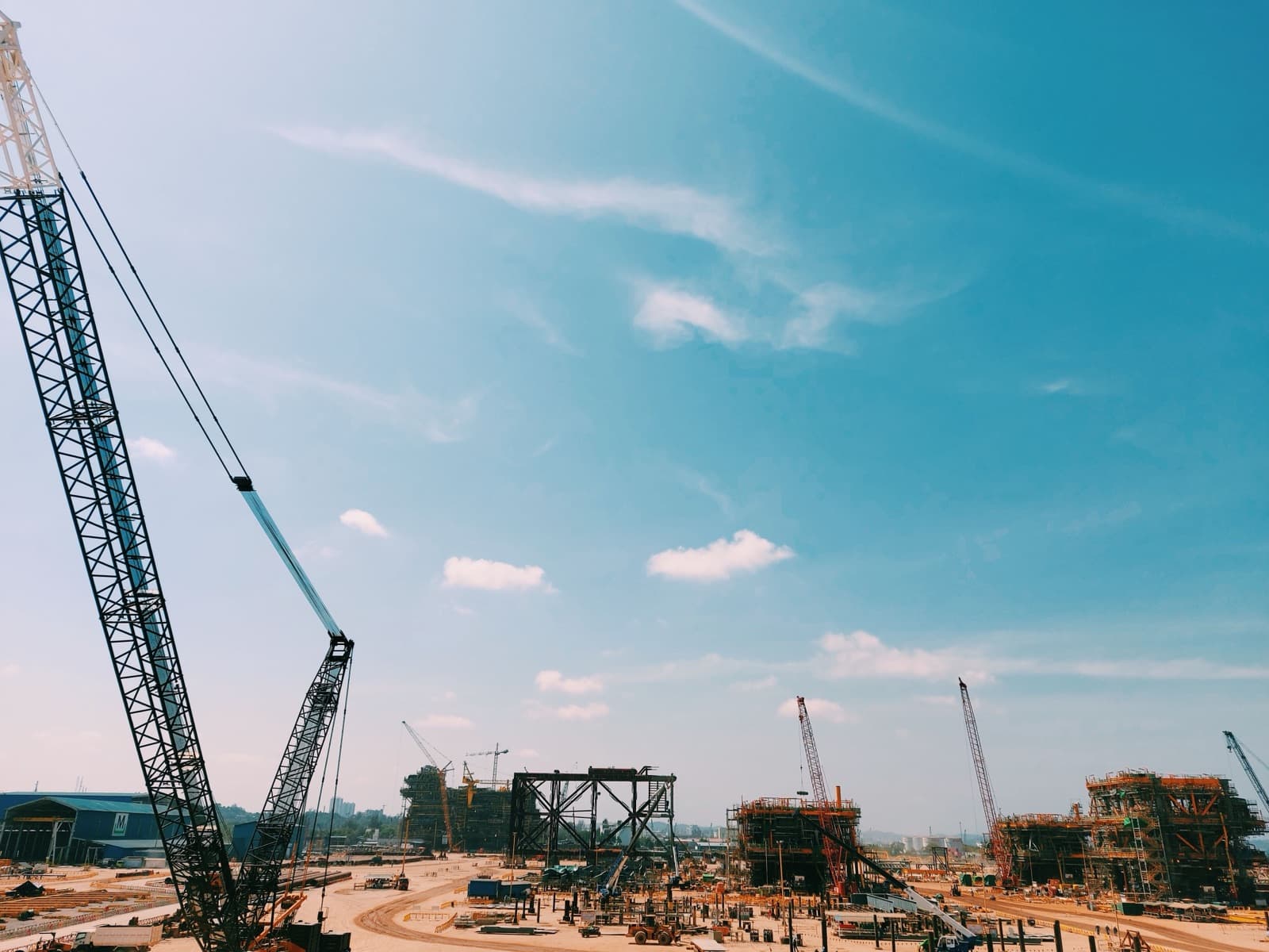 Cranes and structural steel framing at a large construction site
